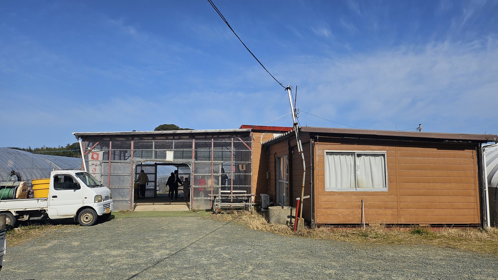 受付のある建物。手前は軽トラック、左奥にハウスが続きます